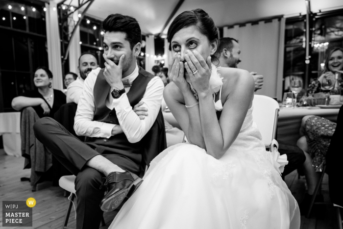 Photo by: <a href="https://www.wpja.com/contests/2019-v18/best-wedding-photographers/2566271">Sybil Rondeau - Nantes </a> Château La Forêt humor wedding photo | Bride and groom watching a surprise video during reception