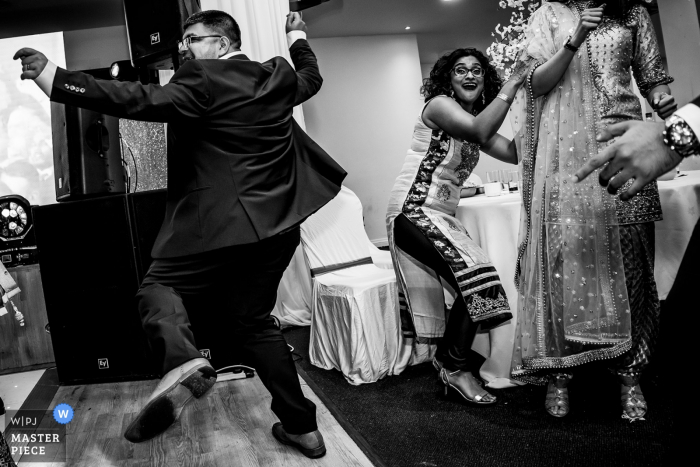 Photo by: <a href="https://www.wpja.com/contests/2019-v18/best-wedding-photographers/2566312">Rohit Gautam - Bedford Bedfordshire</a> England Wedding Reportage - Reception Venue Photography - One guy dancing like there is no one on the dance floor and a guest trying to get away from bring hit by dancers moves.
