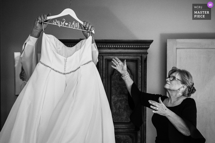 Photo by: <a href="https://www.wpja.com/contests/2019-v18/best-wedding-photographers/2566409">Todd Laffler - High Bridge New Jersey</a> Bride's mom reaches for wedding dress from bride's dad who got it down | New Jersey wedding photographer