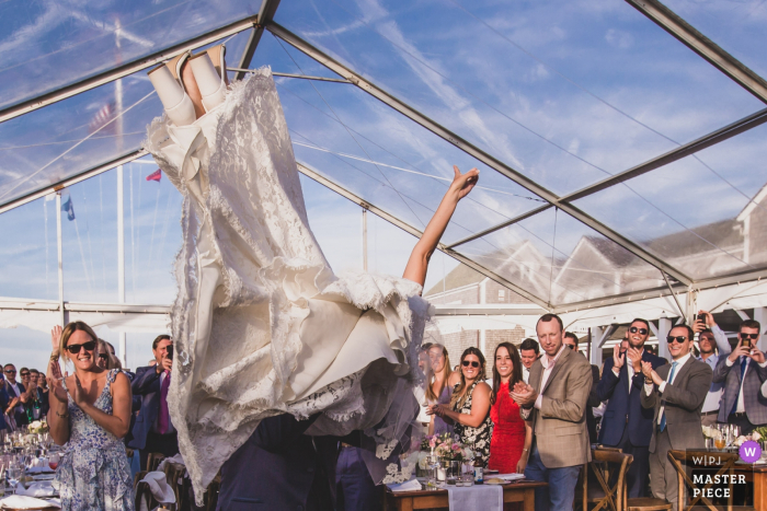 Photo by: <a href="https://www.wpja.com/contests/2019-v18/best-wedding-photographers/2567321">Katie Kaizer - Nantucket Massachusetts</a> Great Harbor Yacht Club - Nantucket Island Wedding Photography | Groom picking Bride up just as they entered the tent for their reception and first dance.