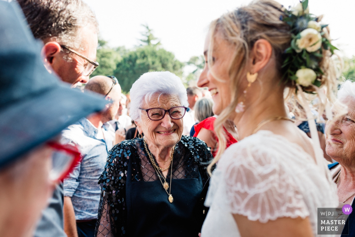Photo by: <a href="https://www.wpja.com/contests/2019-v18/best-wedding-photographers/2567355">Damien Dohmen - Pau </a> Church in Simacourbes, France wedding photo showing the happiness of the grandmother