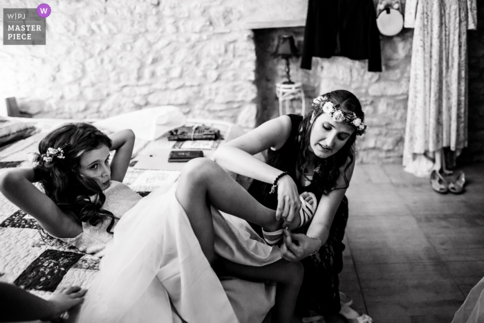 Photo by: <a href="https://www.wpja.com/contests/2019-v18/best-wedding-photographers/2567542">Ludovic Lieffrig - Saint-Mathieu-de-Tréviers </a> Domicile à Albi wedding photo of the bride putting her daughter's shoes on.