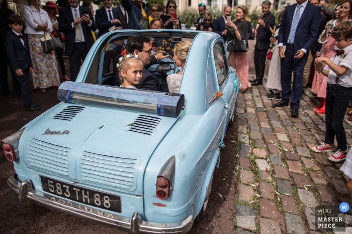 Photo by: <a href="https://www.wpja.com/contests/2019-v18/best-wedding-photographers/2567612">Isabelle Dohin - Andernos les Bains </a> Wedding picture from Château La Ferrade Latresne France (Reception Venue) | Bride and groom and their daughter leave the church in small, vintage auto