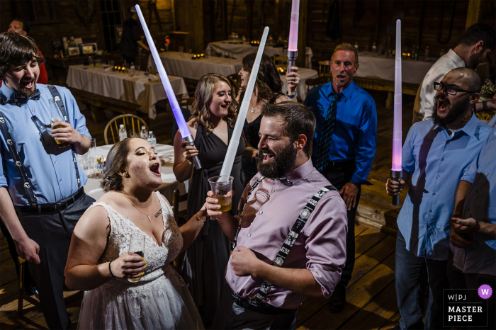 Photo by: <a href="https://www.wpja.com/contests/2019-v18/best-wedding-photographers/2568179">James Nix - Charlotte North Carolina</a> Circle M City venue event photography | The bride and groom dance with light sabers during their wedding reception on "Star Wars Day"