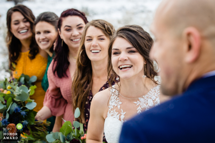 A noiva e as damas de honra reagem aos votos do noivo Victor, Idaho, foto da cerimônia de casamento ao ar livre: a noiva e as damas de honra reagem aos votos do noivo