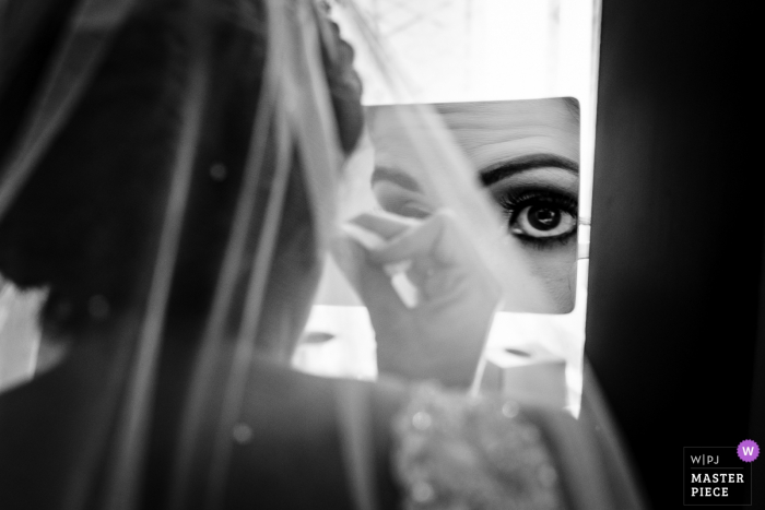 Photo by: <a href="https://www.wpja.com/contests/2019-v19/best-wedding-photographers/2569369">JD Land - Marlton New Jersey</a> NJ wedding photo from Hotel during prep | Bride making some last minute adjustments to her makeup in a magnifying mirror