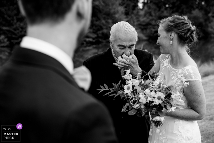 Photo by: <a href="https://www.wpja.com/contests/2019-v19/best-wedding-photographers/2569409">Fille Roelants - Antwerpen Antwerpen</a> Flanders photography at the ceremony - the bride's father hand kisses his daughter before handing her to the groom at the start of the ceremony