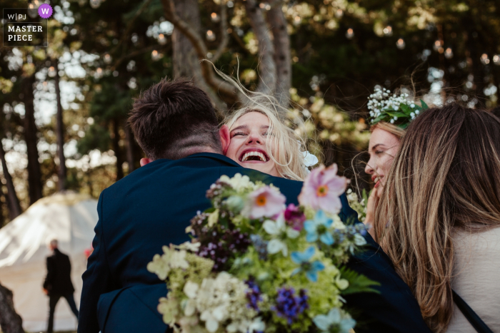 Photo by: <a href="https://www.wpja.com/contests/2019-v19/best-wedding-photographers/2569655">Zoe Brunner - Edinburgh Midlothian</a> Ravensheugh Log Cabin, Scotland Photographer: Wedding guests congratulate the bride, immediately after the ceremony.