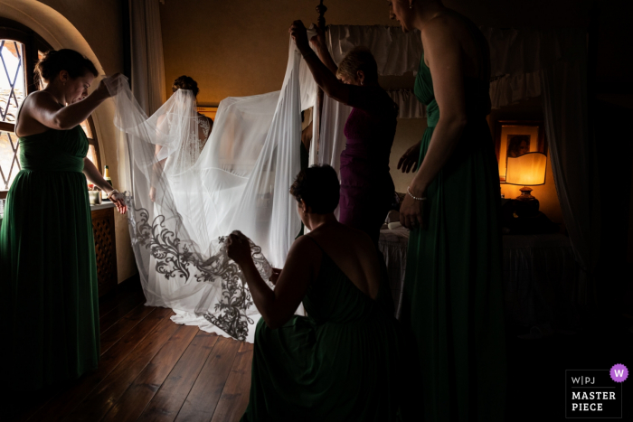 Novia de Toscana preparándose con algo de ayuda - Foto de reportaje de boda