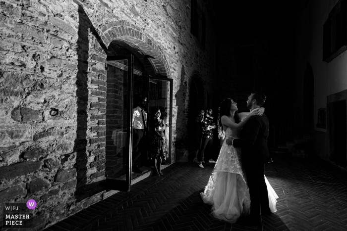 Imagen de recepción de boda en Toscana en blanco y negro del primer baile con poca luz