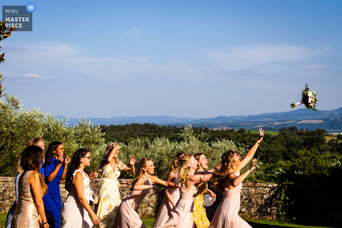 Villa la Palagina wedding venue image of the ladies at the wedding reception during the launch of the bouquet the girls challenge each other to take it 