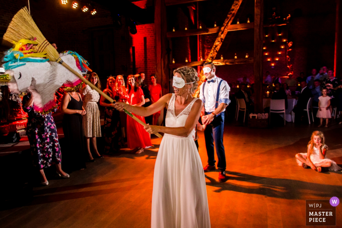 Imagem da recepção de casamento de Kasteel van Hoen da noiva com uma vassoura que bate em uma piñata.