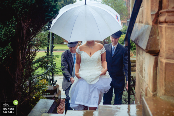 Stirlingshire wedding reportage photographer at a church in Scotland - Photo: Bride arrives during a downpour. 