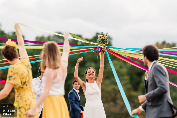 Photo by: <a href="https://www.wpja.com/contests/2019-v19/best-wedding-photographers/2570510">Damien Dohmen - Pau </a> The bride cuts the ribbon to know who is the next to get married | Bergerac, France wedding venue