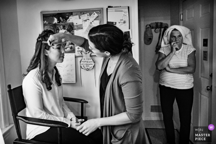 New York City wedding photographer captured a getting ready image of the bride having her makeup done.