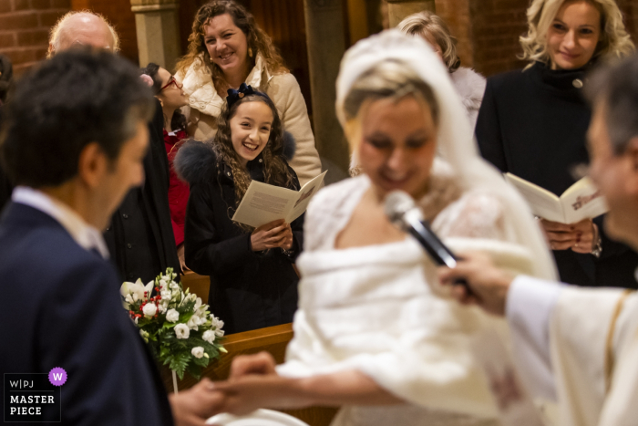 Fotografia ślubna w Mediolanie: podczas ceremonii panna młoda mówi do mikrofonu, gdy świadkowie patrzą z emocjami.