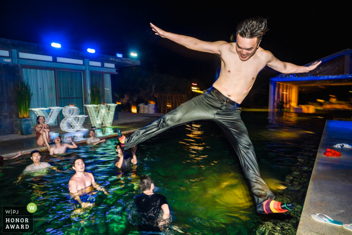 Fotografía de acción del lugar de la boda de Sava Beach Villa: el novio estaba saltando a la piscina después de la fiesta.