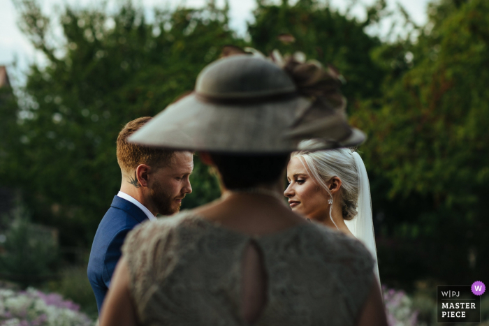 A imagem do casamento de Chateau de Bijou, França contém: Casal durante a cerimônia com a mãe da noiva lendo