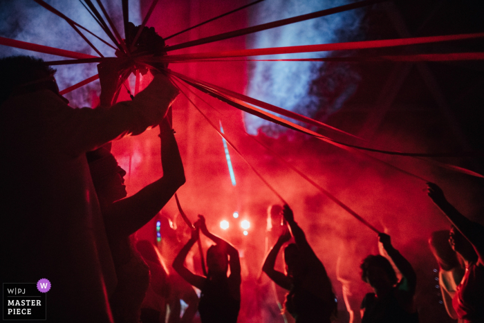 Viseu, Portugal fotógrafo de bodas: juegos de ramo bajo luces rojas y niebla.