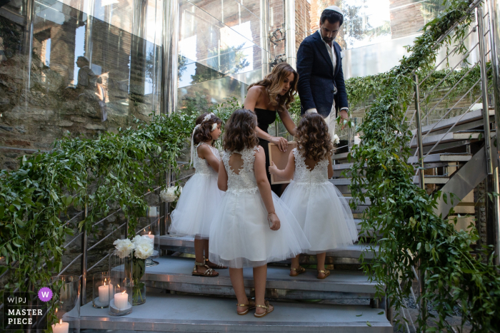 Turkey wedding ceremony image contains: A woman helps flower girls on the stairs leading to the ceremony