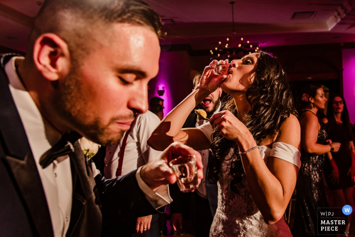 Venue: Royalton on the Greens | Bride and groom take shots in this wedding picture