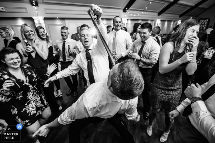 Wedding reception photography | Guest grabs tie of another guest on dance floor at Lake Mohawk Country Club, New Jersey