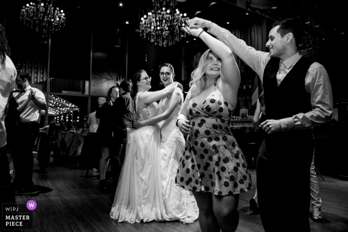 Photo by: <a href="https://www.wpja.com/contests/2019-v19/best-wedding-photographers/2571872">Esther Gibbons - Montreal Quebec</a> Wedding Event Photography at the Hotel 10, Montreal, Quebec - Brides dance together surrounded by their wedding guests dancing