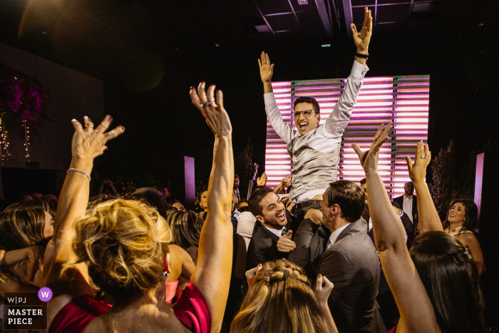 Photo by: <a href="https://www.wpja.com/contests/2019-v19/best-wedding-photographers/2571900">Renan Radici - Porto Alegre Rio Grande do Sul</a> Mahala Eventos wedding image of groom being thrown up on the dance floor.