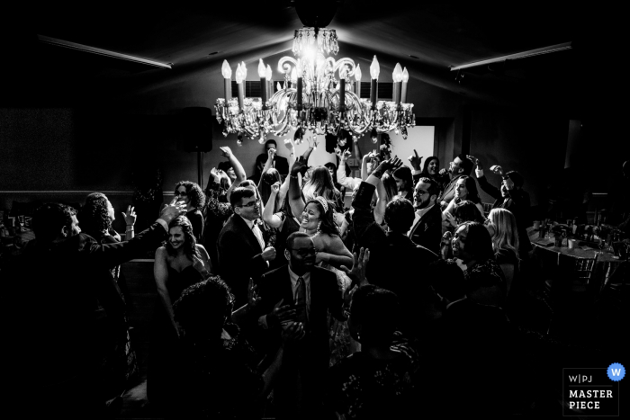 Photo by: <a href="https://www.wpja.com/contests/2019-v19/best-wedding-photographers/2571950">Brittany Diliberto - Arlington Virginia</a> Top of the Town - Arlington VA - Wedding photo of the Bride & Groom in the center of a hectic dance floor with epic backlight
