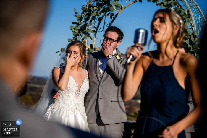 Photo by: <a href="https://www.wpja.com/contests/2019-v19/best-wedding-photographers/2571982">Brittany Diliberto - Arlington Virginia</a> Wedding photographer for the Bluemont Vineyard, Virginia, USA | A talented bridesmaid sings a moving song to the bride and groom
