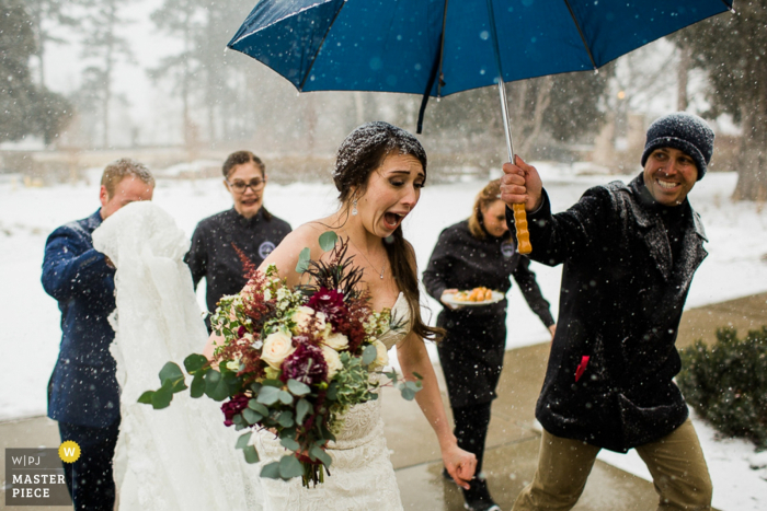 Colorado wedding photo of the bride walking inside to get warm from the snow.