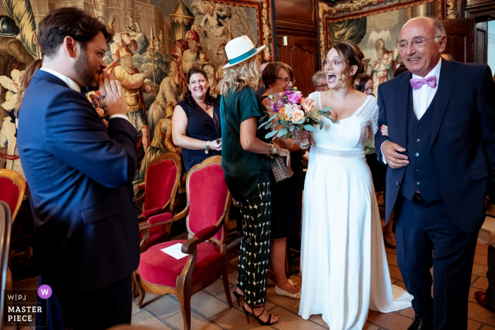 Vallon Pont d'Arc | The bride is so happy to discover the groom at the townhall as she enters the ceremony with her father.