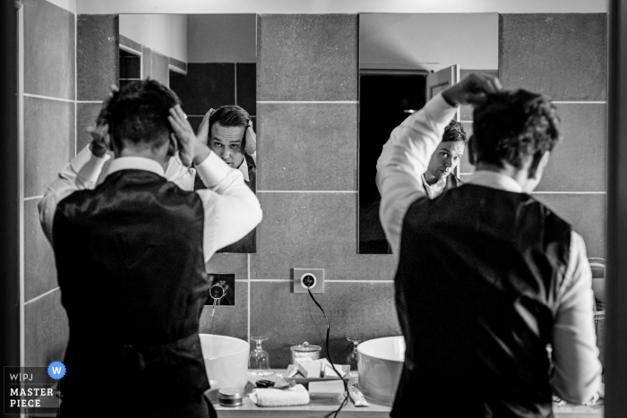 Mas de Peint, Camargue, France wedding day photos of the groom and his brother are doing each other's hair.