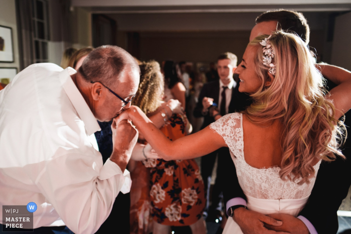 Devonport House, fotografia di location per matrimoni a Londra in stile reportage | Padre che bacia la mano della sposa sulla pista da ballo