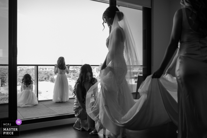 Fotografo di matrimoni di Melbourne: mentre la sposa indossa le scarpe, le bambine guardano gli altri bambini che giocano nel parco giochi.