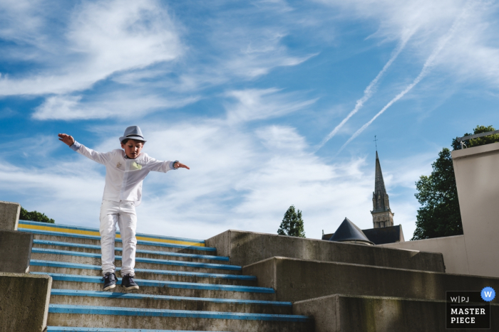 Brittany Reception venue photography showing Child at play on the stairs wearing a hat