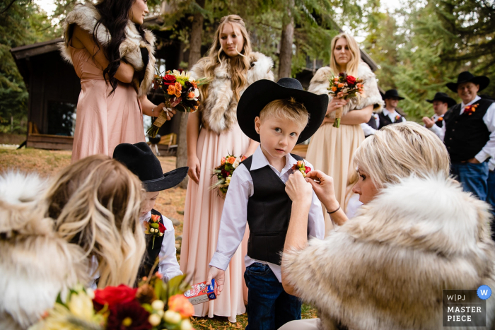 Priest Lake, Idaho photo of the ring bearer getting final preparation help by bridesmaids. 