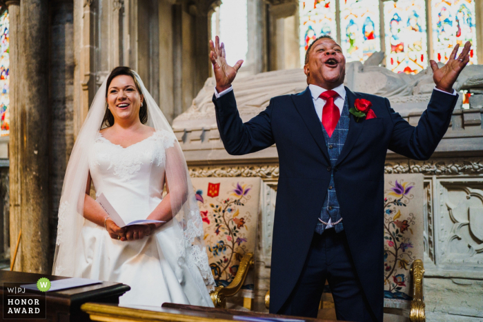 Foto de casamento de Ely Cathedral, Ely, Cambridgeshire - noivo cantando no topo de seus pulmões na catedral de Ely