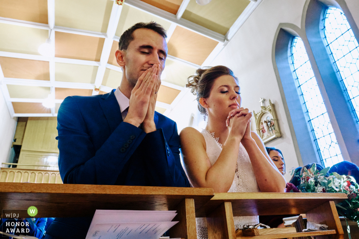 Holy Cross Church, Lichfield wedding photo from the church of the Bride and groom praying together 