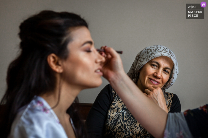 Turkije Home Fotografie op trouwdag | Moeder kijkt toe hoe bruid haar make-up gedaan krijgt