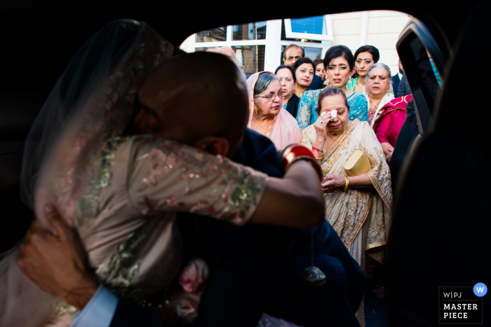 Photographie de mariage à domicile à Wolverhampton, Royaume-Uni | Mariée dans la voiture quittant la maison familiale - départ émotionnel