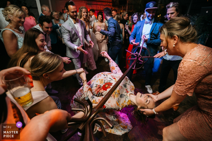 Photo by: <a href="https://www.wpja.com/contests/2019-v20/best-wedding-photographers/2576927">Fille Roelants - Antwerpen Antwerpen</a> Flanders wedding photography at the reception venue - Someone picked a cloth hanger and engaged everyone to start limbo dancing underneath!