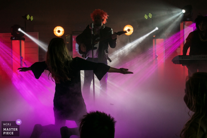 Malopolskie Reception Venue Photography | At the wedding, the groom is singing for the bride under purple DJ lights