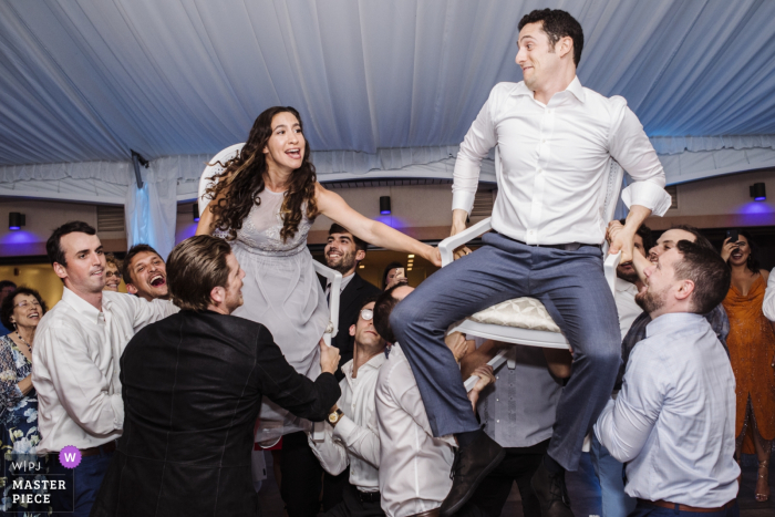 The Estate at Eagle Lake NJ wedding venue photography showing the Joyful celebration as the bride and groom are lifted by the guests The Estate at Eagle Lake NJ wedding venue photography showing the Joyful celebration