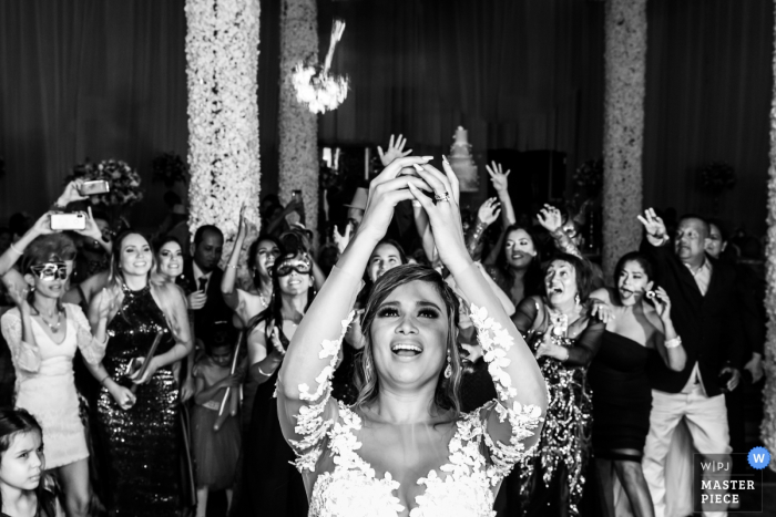 Miranda bride tossing her flower bouquet to the female wedding guests