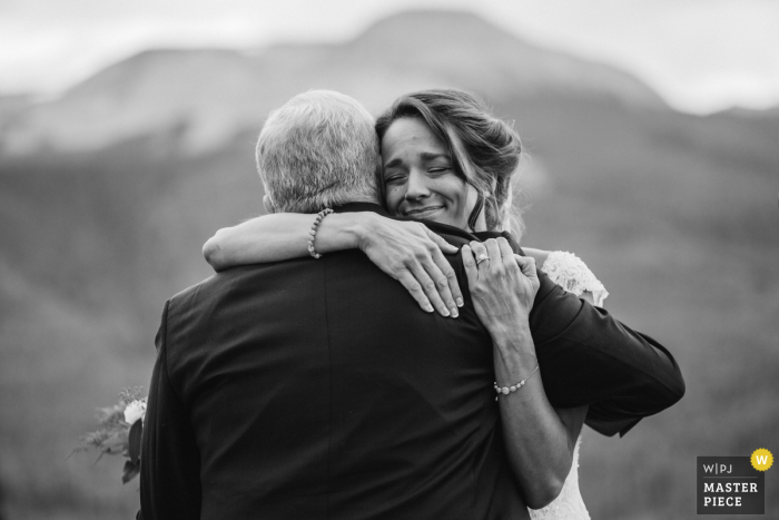 Cerimônia de casamento ao ar livre no Colorado Imagem da noiva abraçando o pai após a cerimônia