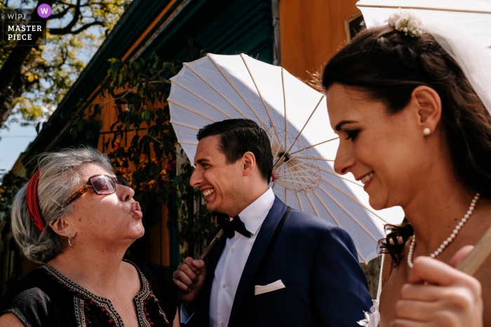 Foto de boda MX de la ciudad de Oaxaca de un invitado a la boda con los novios en la calle