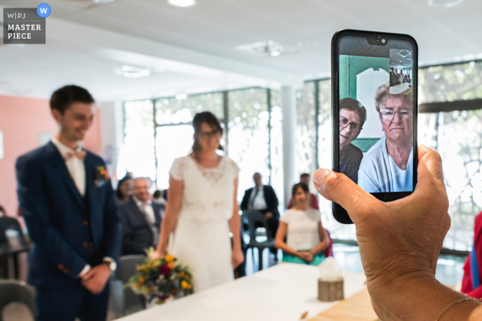 Agen, França, imagem de casamento de cerimônia virtual por telefone de um convidado remoto vendo os noivos