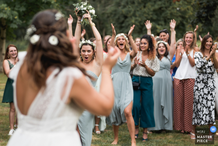 Fotografia di matrimonio all'aperto in Francia dal Domaine de Pécarrère del lancio del bouquet