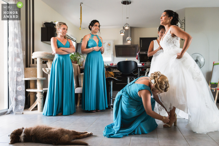 Andiran, France wedding photo of the bride getting help with her shoes